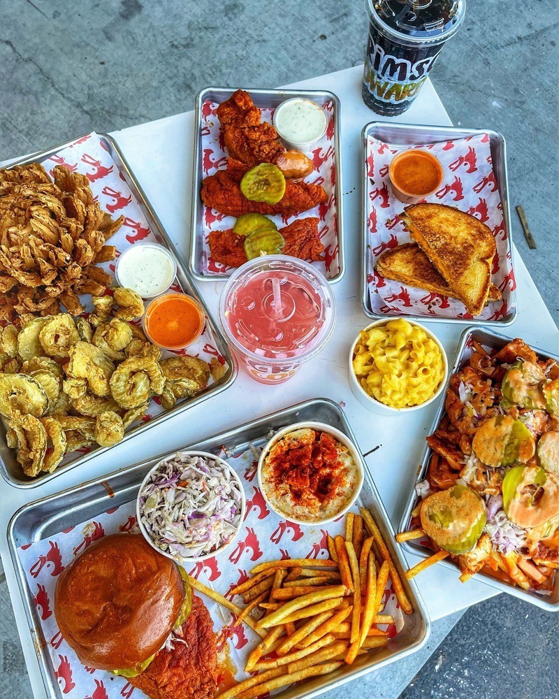 Game day spread of Nashville hot chicken trays, fries and drinks